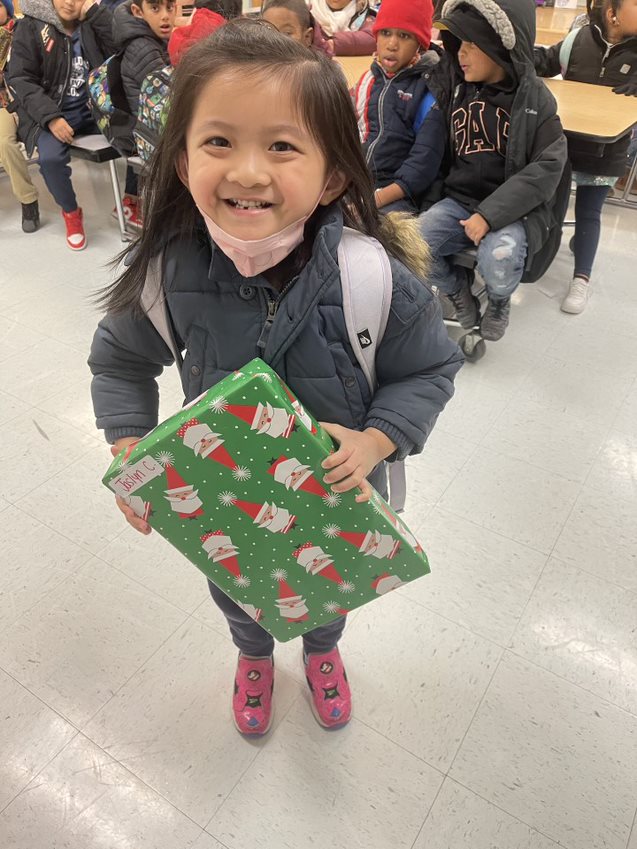 Jaslyn, a student at a Child Center afterschool program, receives a gift from our holiday toy drive