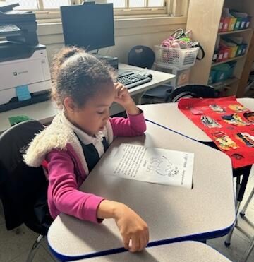 Jismerlyn, a participant in The Child Cente'rs Literacy Leaders sight words program, is at her desk completing a worksheet.