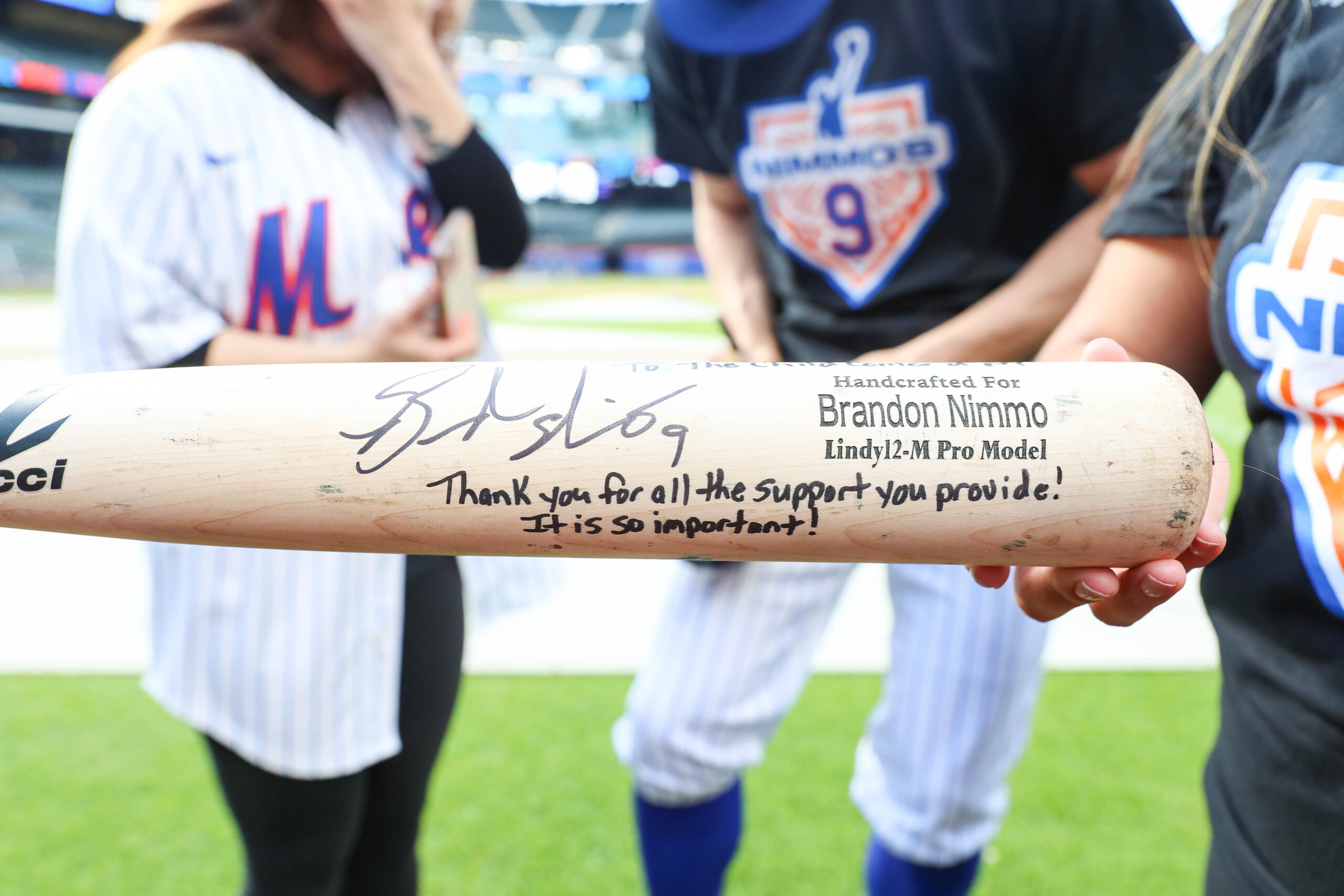 NY Mets Outfielder Brandon Nimmo presents a bat to be displayed at The Child Center of NY's Cohen Family Wellness Center