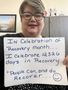 In honor of recovery month, blog author julia floyd-ventura holds a sign with how many days she has been in recovery. 