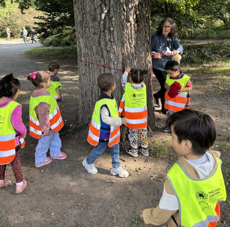 Escalera Head Start Director Tracey Elting and students of the 3-year-old class measure the circumference of a tree.