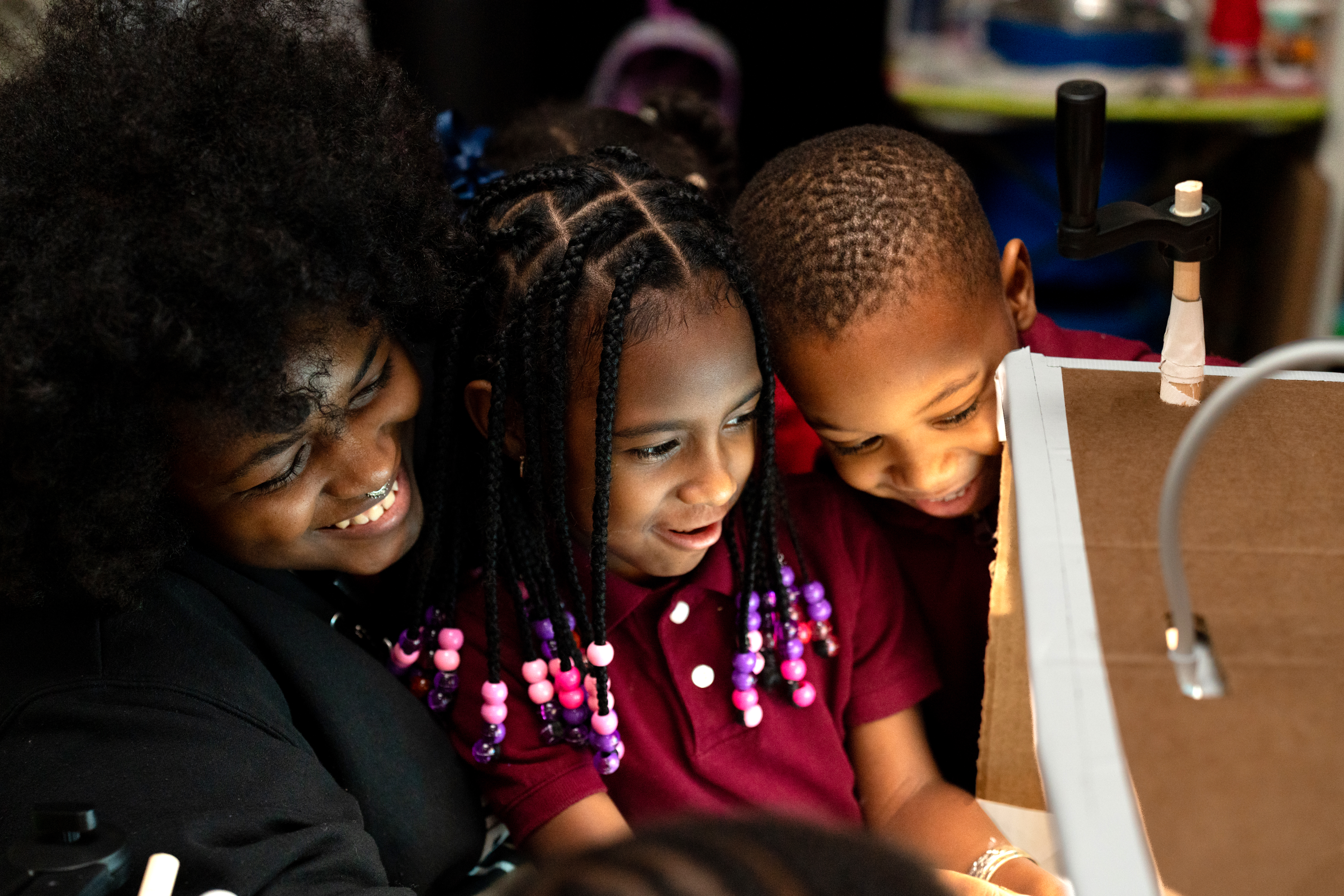 Child Center of NY Afterschool Group Leader and Creative Artist Shaymon Thomas-Simmons with two afterschool program participants engage with shadow puppets.