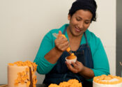 Noelia, a Cash+Community Works participants is decorating a cake for her business, Noelia's Sweets.