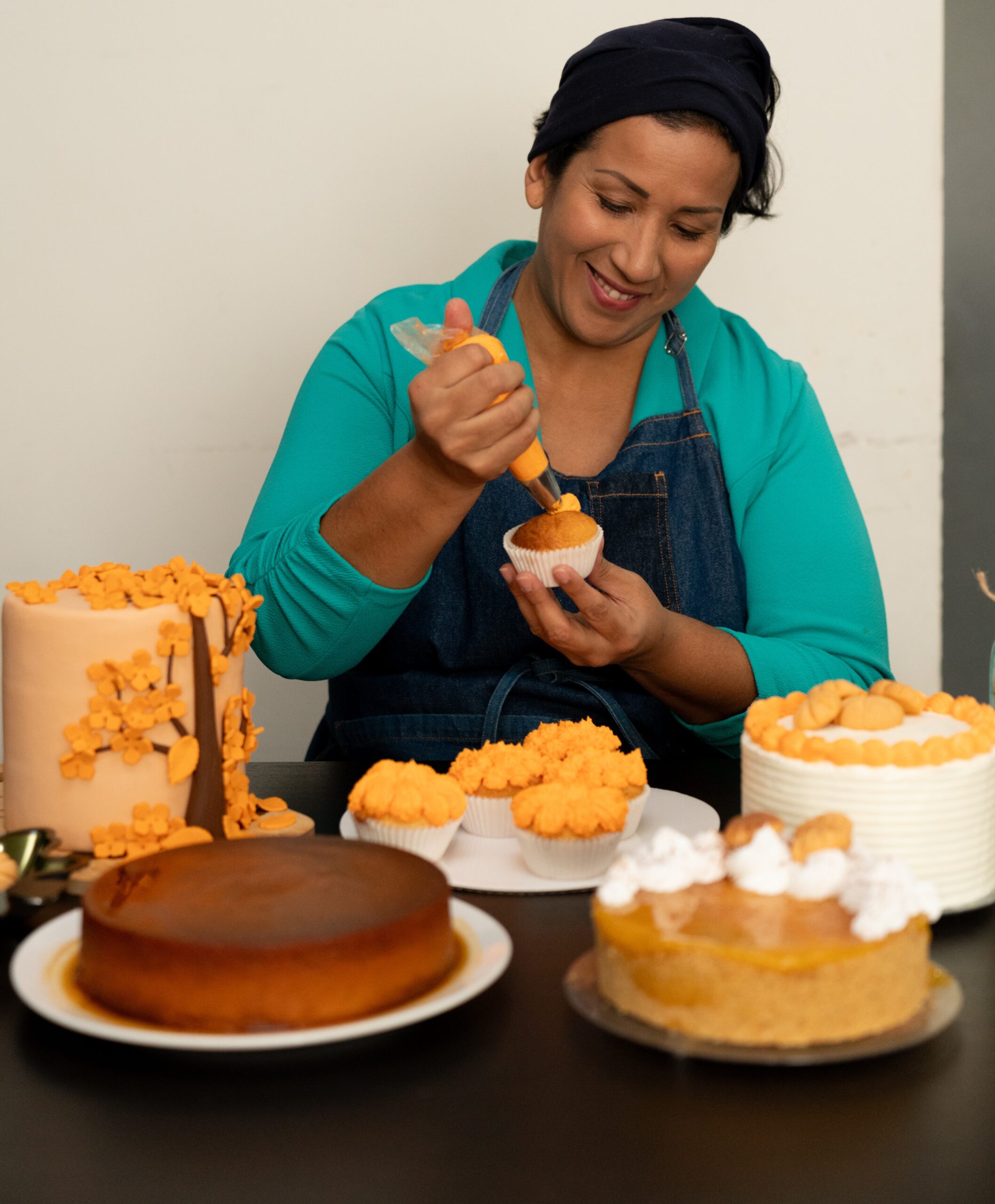 Noelia, a participant of Cash+Community Works, decorates a cake she baked for her business, Noelia's Sweet Delights.