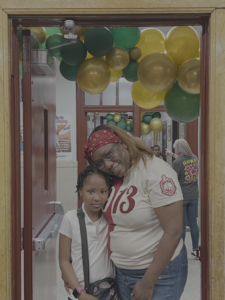 PAPP president Judeen poses standing with her third grade daughter at an afterschool event.