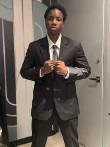 Ma'Chi, a teen at the Child Center Residential Treatment Facility (RTF) stands dressed in a suit for The Child Center's gala.
