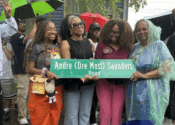 Penny and her family and a councilwoman stand in the rain holding a street sign.